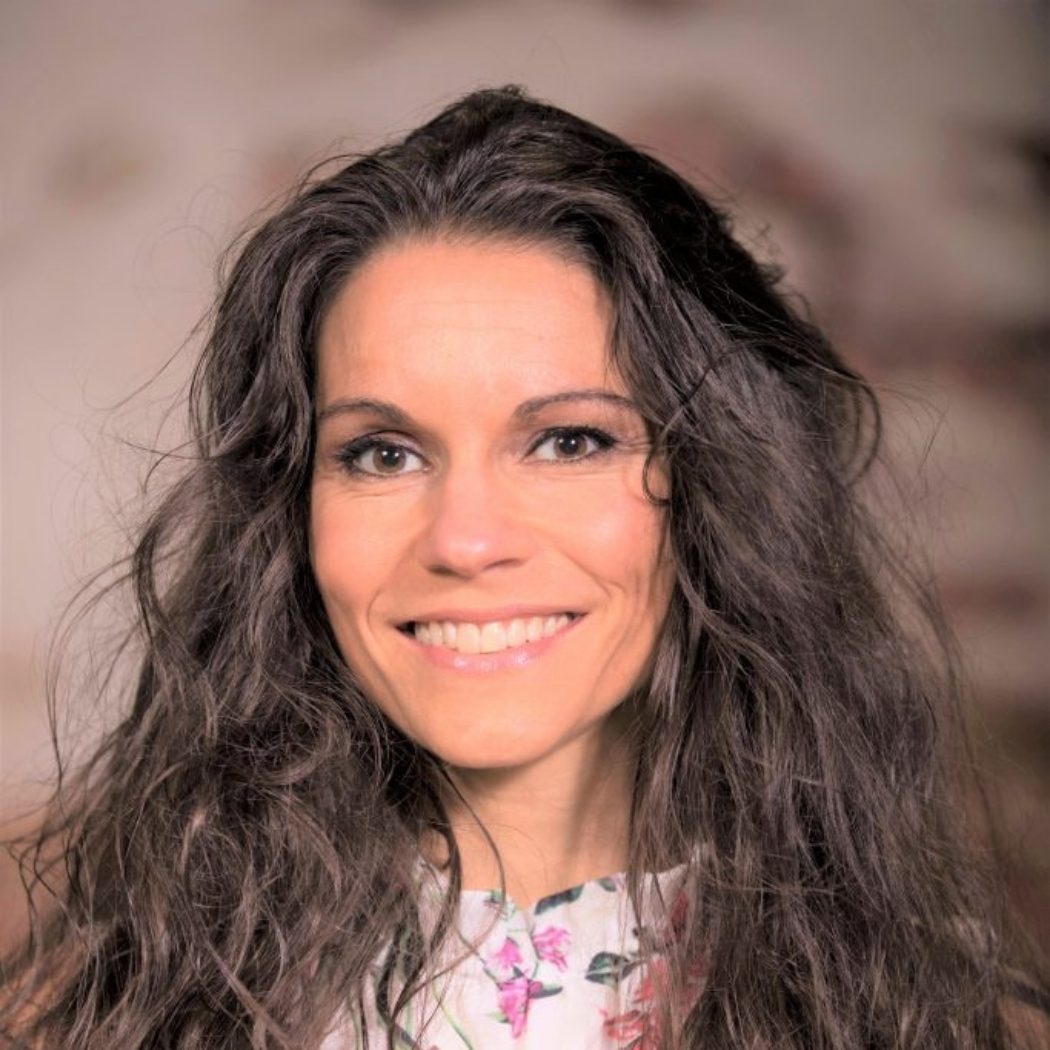 Julia Vosen lächelt in der Natur 